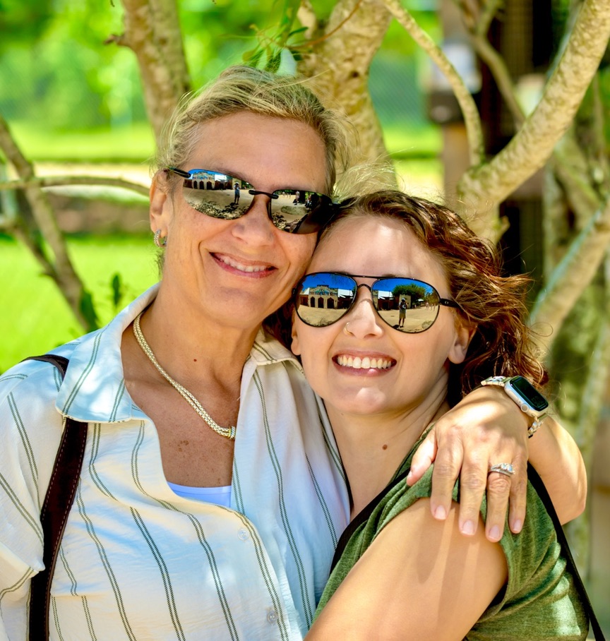 Mother and adult daughter sharing a relaxed smiling lifestyle portrait on the Alabama Gulf Coast.