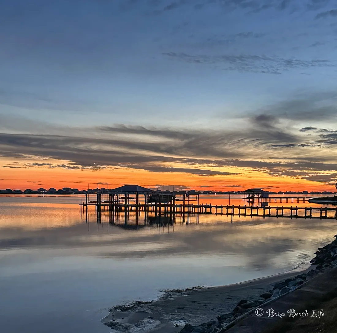 Little Lagoon sunset dock reflections in Gulf Shores, Alabama, photographed as fine art coastal wall art for beach homes, condos, and collectors.